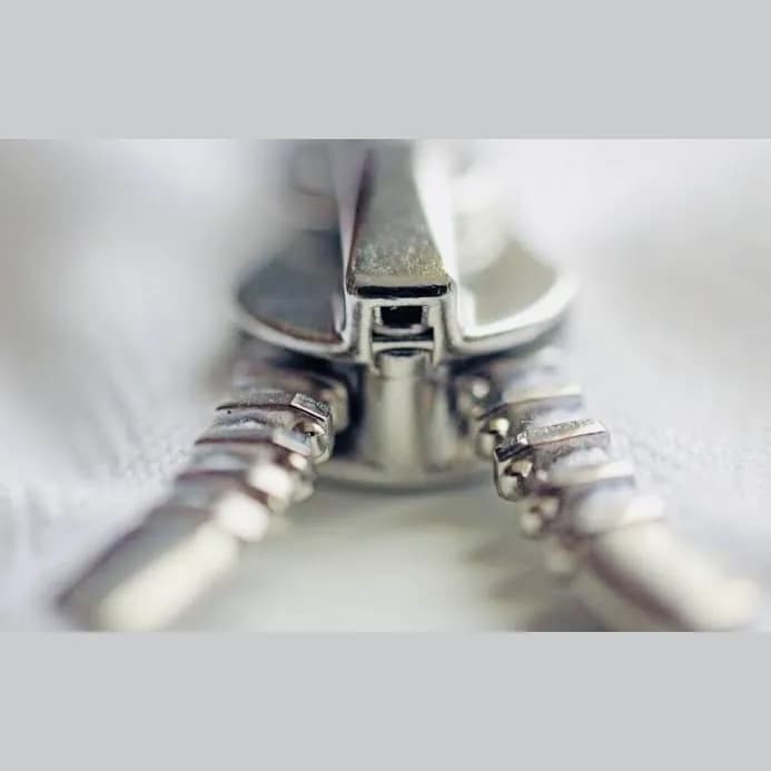 Sample photo 12, Zipper Slider (Front): a close-up of the front of a metal zipper slider and its teeth