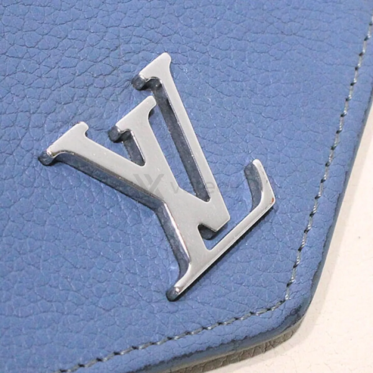 Sample photo 2, Logo: a close-up of the metal LV logo on the wallet's flap
